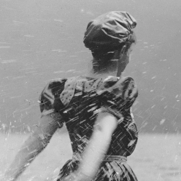 Mujer en la playa, chapoteando en el agua.